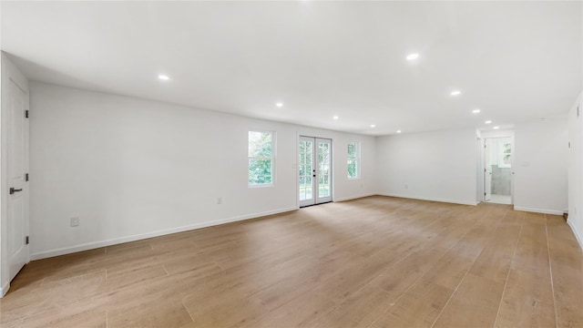 unfurnished living room with recessed lighting, light wood finished floors, baseboards, and french doors