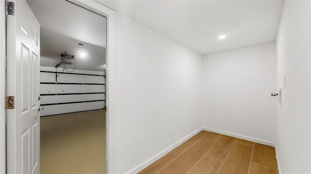 hall with wood finished floors, baseboards, and recessed lighting