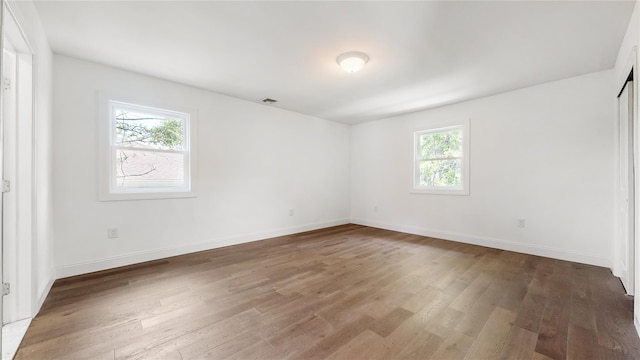 spare room with wood finished floors and baseboards