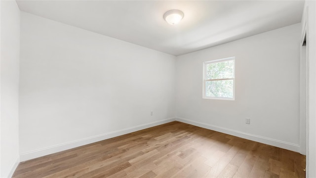 empty room with light wood-style flooring and baseboards
