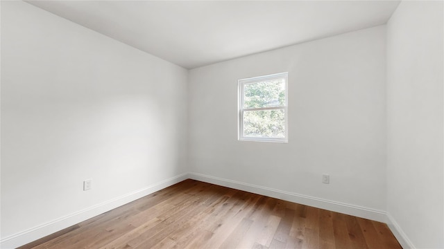 unfurnished room featuring baseboards and light wood-style flooring