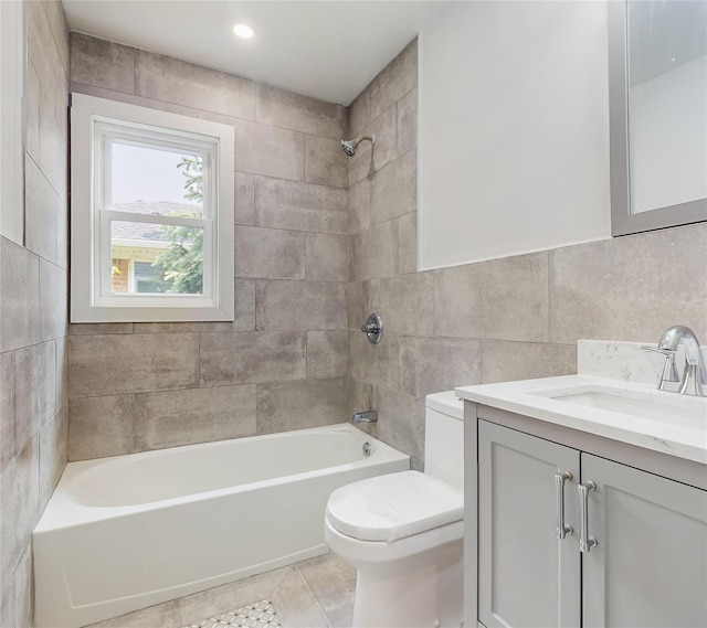 full bathroom featuring tile walls, toilet, shower / washtub combination, vanity, and tile patterned flooring
