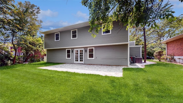 back of property with a patio area, a yard, and french doors