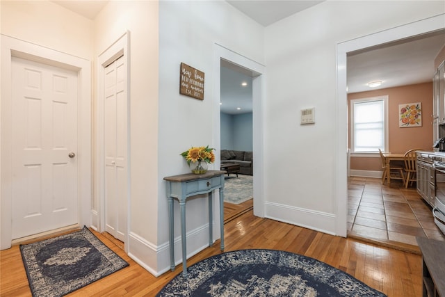 hallway featuring wood-type flooring and baseboards