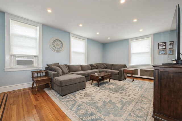 living area with light wood finished floors, baseboards, cooling unit, and recessed lighting