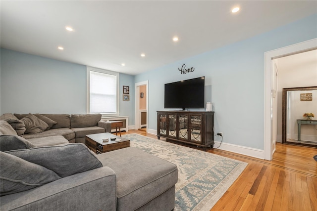 living room featuring light wood-type flooring, baseboards, and recessed lighting