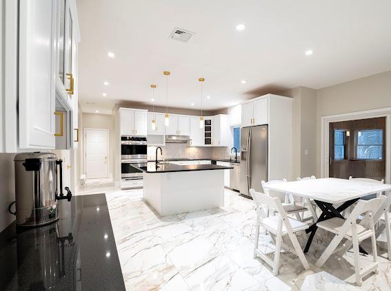 10-12 Damian Ct, Chester, NY 10918 - kitchen featuring stainless steel appliances, dark countertops, recessed lighting, a center island with sink, and backsplash
