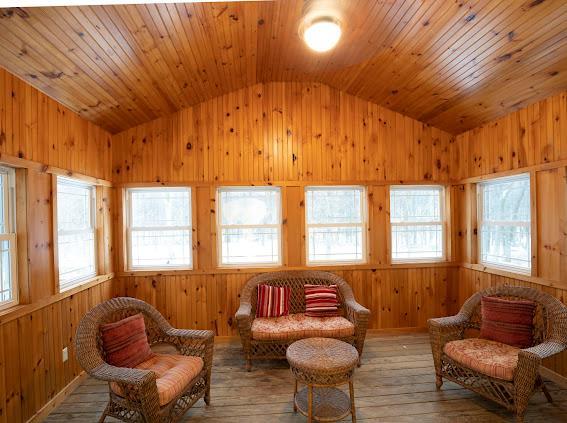 10-12 Damian Ct, Chester, NY 10918 - sitting room with vaulted ceiling, hardwood / wood-style floors, wooden walls, and plenty of natural light