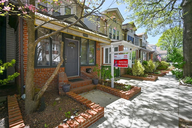 view of front of home with entry steps and brick siding