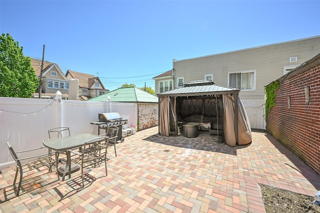 view of patio with a gazebo, a fenced backyard, grilling area, and outdoor dining space