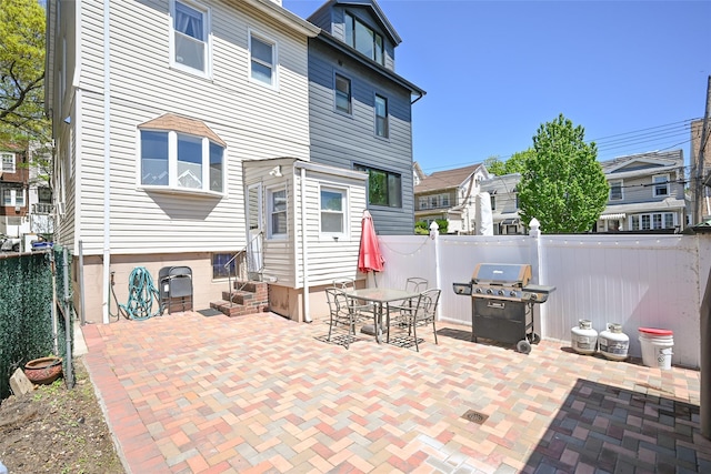 rear view of property featuring entry steps, fence, and a patio