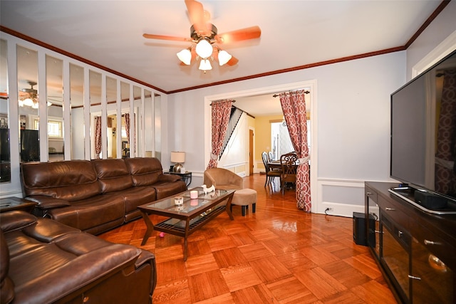 living area with crown molding and ceiling fan