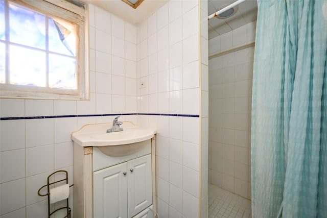 full bath with tile walls, tiled shower, and vanity