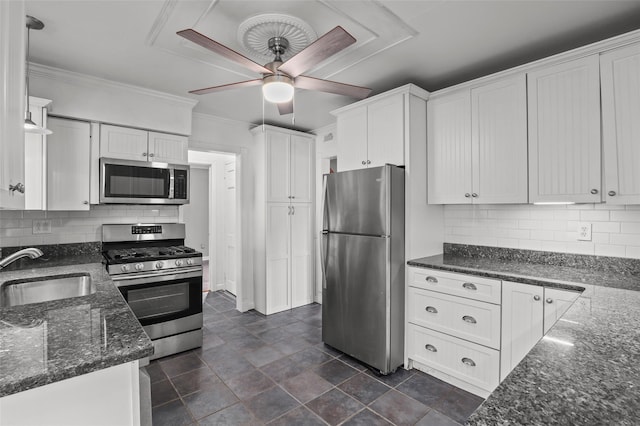 kitchen featuring a ceiling fan, a sink, white cabinetry, appliances with stainless steel finishes, and ornamental molding