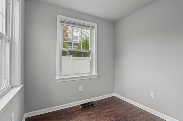 empty room featuring dark wood finished floors and baseboards