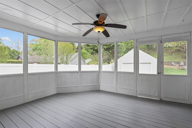 unfurnished sunroom with ceiling fan