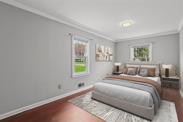 bedroom with wood finished floors, ornamental molding, and baseboards