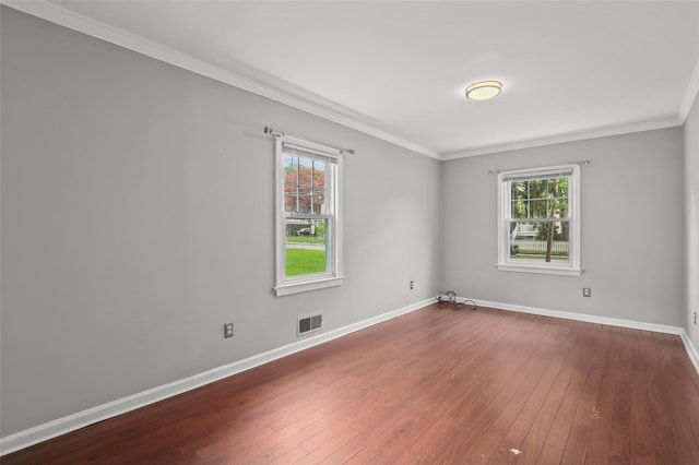 spare room with plenty of natural light, hardwood / wood-style flooring, baseboards, and ornamental molding