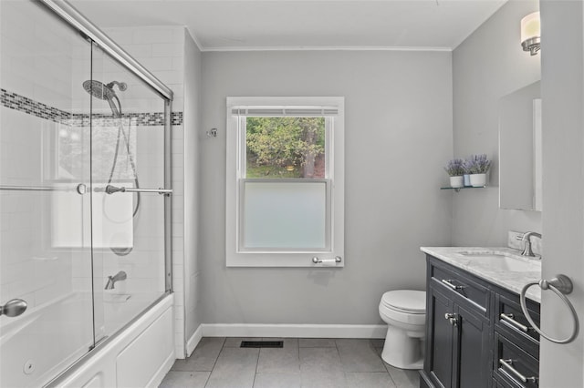 bathroom with baseboards, tile patterned flooring, vanity, and bath / shower combo with glass door