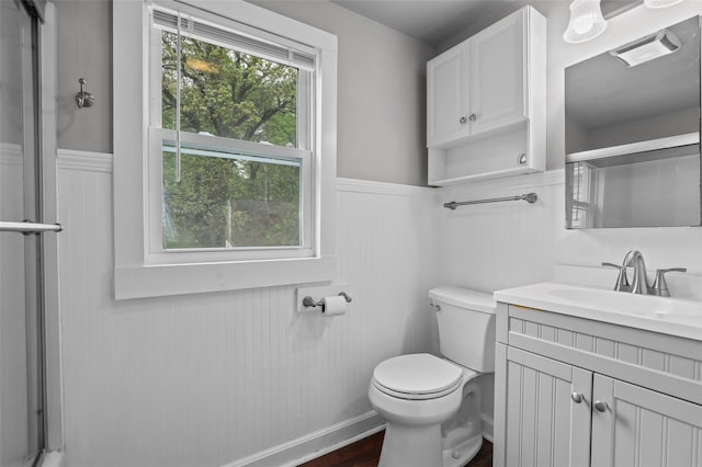 full bathroom with toilet, an enclosed shower, vanity, and a wainscoted wall