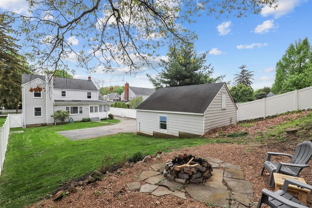 view of yard with a fire pit, an outdoor structure, and a patio