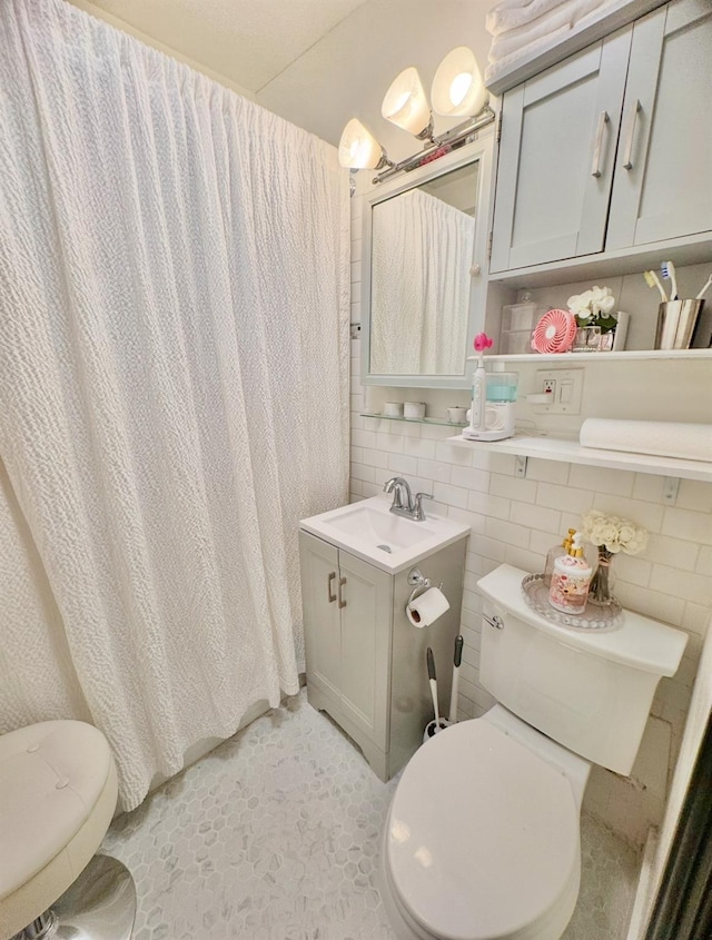 bathroom with a sink, a shower with shower curtain, and toilet