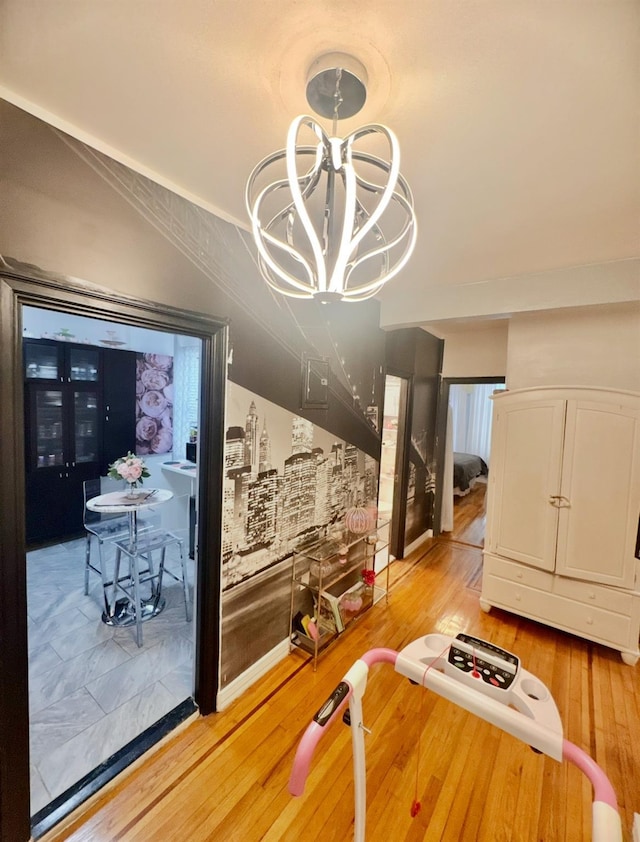 hall with a chandelier and light wood-style flooring