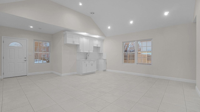 unfurnished living room with recessed lighting, vaulted ceiling, and light tile patterned floors