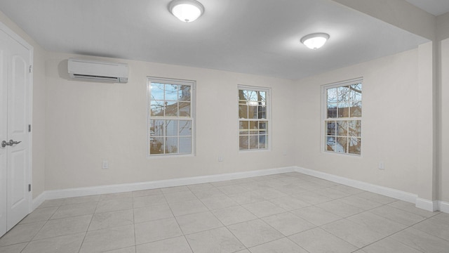 empty room featuring baseboards, a wall mounted air conditioner, and light tile patterned floors