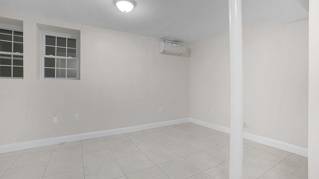 spare room featuring tile patterned floors, baseboards, and a wall mounted air conditioner