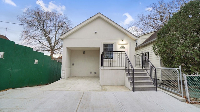 view of front of house with fence and stucco siding