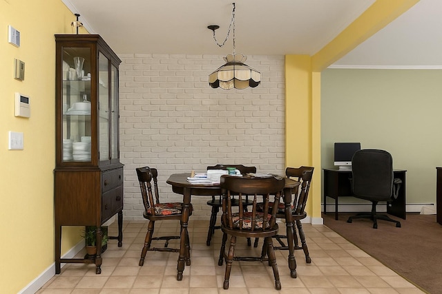 dining space featuring baseboards, a baseboard radiator, brick wall, and visible vents