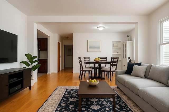 living area with baseboards and light wood-type flooring