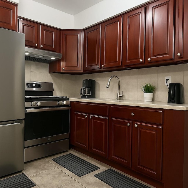 kitchen featuring stainless steel appliances, backsplash, under cabinet range hood, light countertops, and light tile patterned flooring