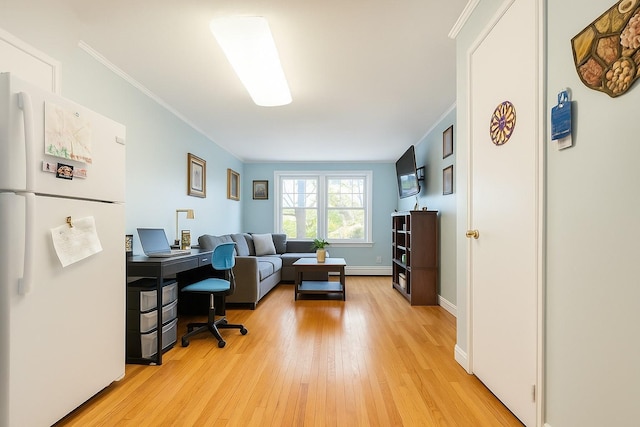 office area featuring crown molding, light wood-style flooring, and baseboards