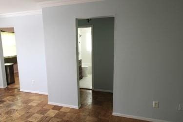 5 Anchorage Ln Unit 4A, Oyster Bay, NY 11771 - spare room featuring crown molding and baseboards