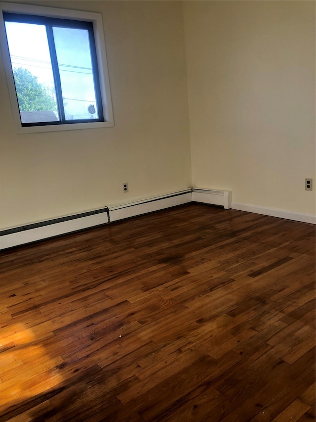 spare room featuring baseboards, dark wood-style floors, and baseboard heating