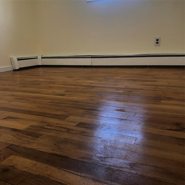 empty room featuring baseboards and hardwood / wood-style flooring