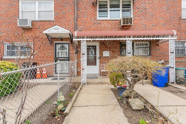 3135 Gunther Ave, Bronx, NY 10469 - doorway to property with brick siding, fence, and cooling unit