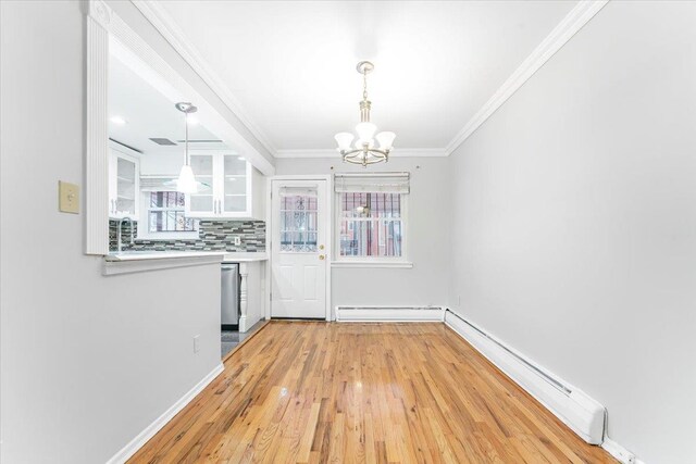 3135 Gunther Ave, Bronx, NY 10469 - unfurnished dining area with an inviting chandelier, plenty of natural light, baseboard heating, and light wood finished floors