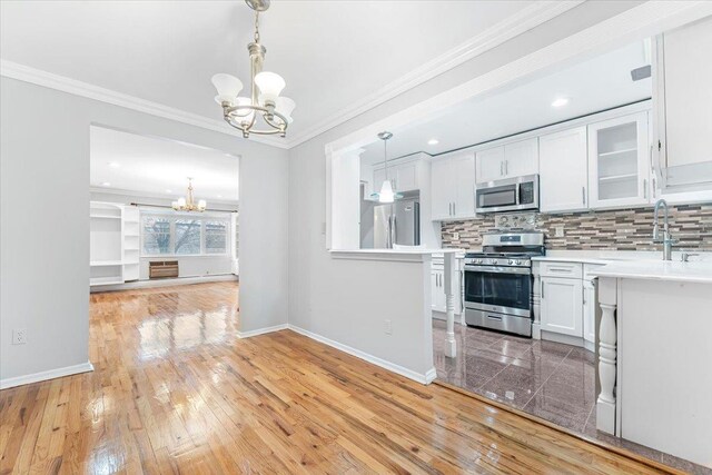 3135 Gunther Ave, Bronx, NY 10469 - kitchen featuring light countertops, a notable chandelier, appliances with stainless steel finishes, and baseboards