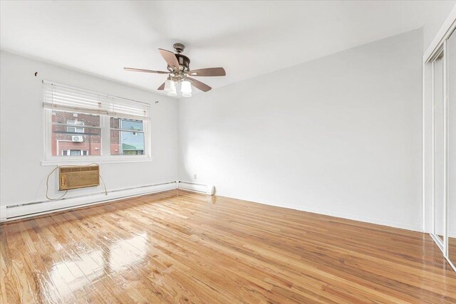 3135 Gunther Ave, Bronx, NY 10469 - empty room featuring a ceiling fan, a wall mounted AC, wood finished floors, baseboards, and a baseboard radiator