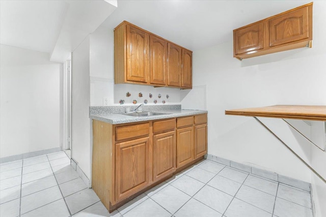 3135 Gunther Ave, Bronx, NY 10469 - kitchen with a sink, light countertops, brown cabinetry, baseboards, and light tile patterned floors