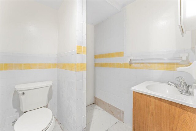 3135 Gunther Ave, Bronx, NY 10469 - half bath featuring tile walls, a wainscoted wall, vanity, and toilet