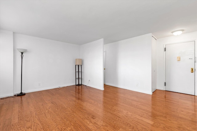 unfurnished room with baseboards and wood finished floors
