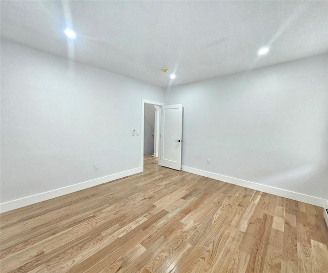 empty room with light wood-type flooring, recessed lighting, and baseboards