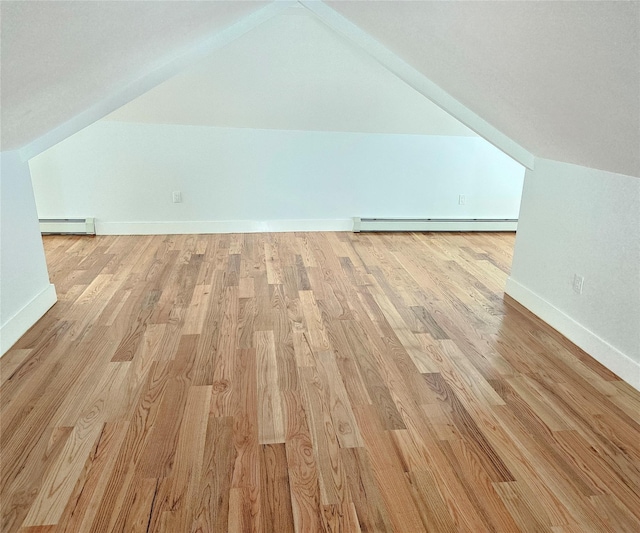 bonus room featuring light wood-style floors, a baseboard heating unit, and lofted ceiling