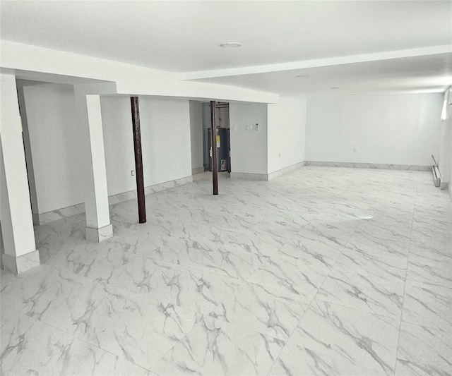 finished basement with baseboards, gas water heater, and marble finish floor