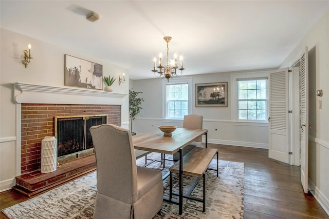 711 Homestead Ave, Maybrook, NY 12543 - dining space featuring a fireplace, a wealth of natural light, a notable chandelier, and wood-type flooring