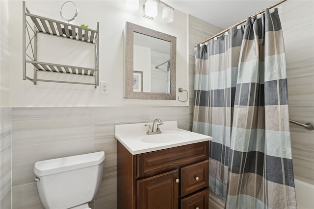 91 Tulip Ave Unit B1, Cartion, Floral Park, NY 11001 - bathroom featuring tile walls, vanity, toilet, and a wainscoted wall